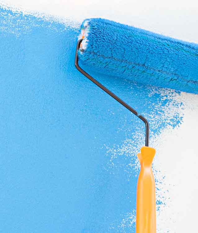 paint roller applying blue paint to wall. 
